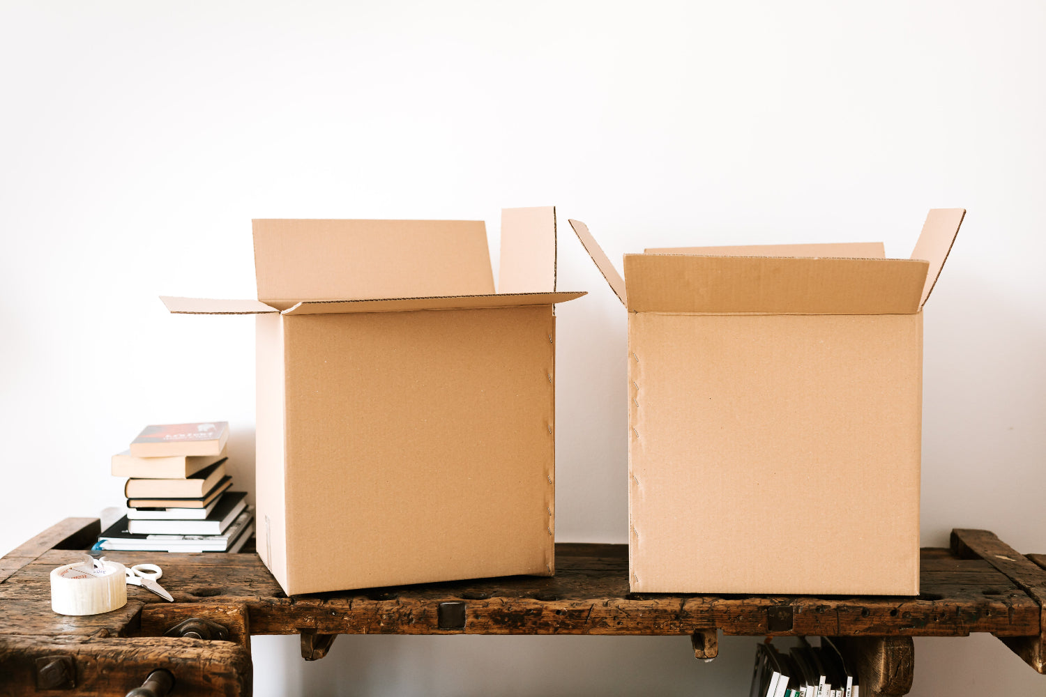 Two open cardboard boxes on a rustic wooden table.